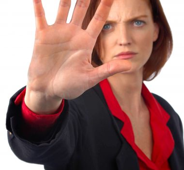 Unhappy women in red shirt and black jacket holding hand out in front of her face