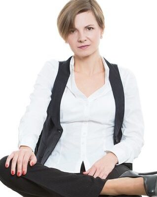 woman sits a chair. legs crossed, body language shows resistance